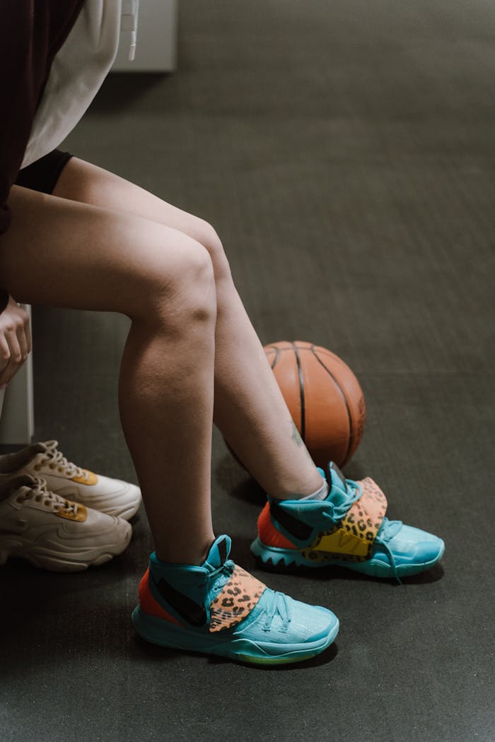 about-01 A sportswoman prepares for the game in a changing room, showcasing her colorful sneakers.